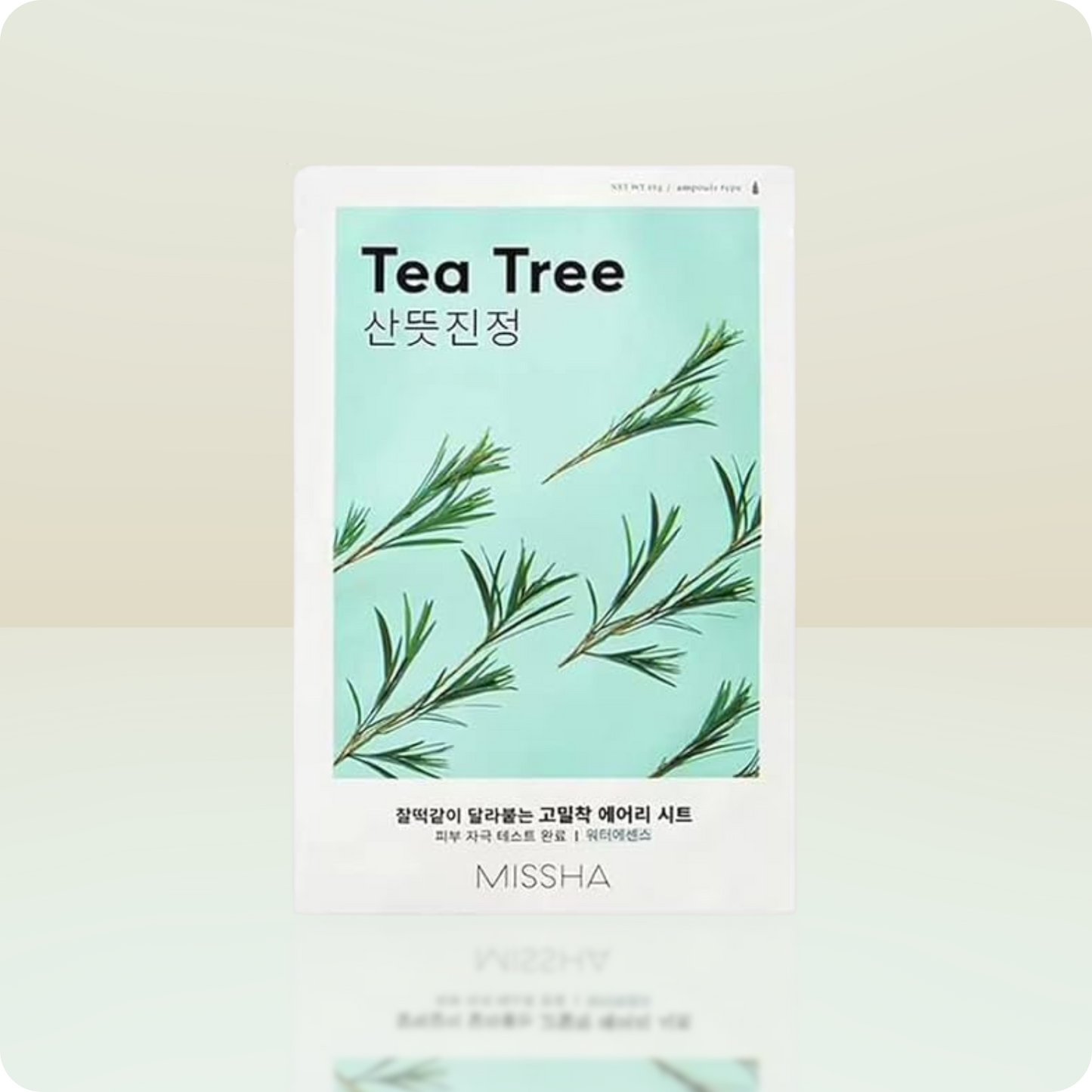 Tea tree sheet mask packaging with green leaves on a light background
